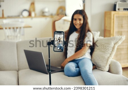 Girl blogger sit on sofa greeting virtual friends, record video for vlog, make call, lead stream with friends use modern tech. Streamer activity, igeneration, fun and home use internet. Communication Royalty-Free Stock Photo #2398301211