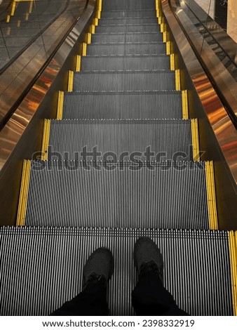 Long Metal Mall stairs with guys feet showing that he is looking downstairs