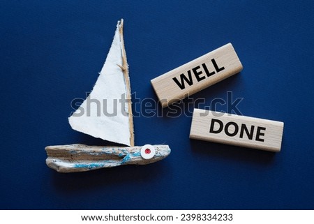 Well done symbol. Wooden blocks with words Well done. Beautiful deep blue background with boat. Business and Well done concept. Copy space.