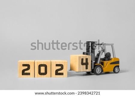 2024 happy new year background. new year industrial concept, forklift carrying box to complete 2024 text isolated on grey background. Royalty-Free Stock Photo #2398342721