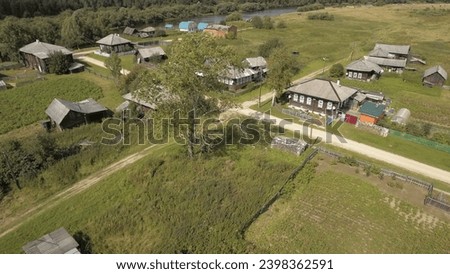 Top view of old Russian village in forest in summer. Stock footage. Russian village located in green clearing with forest in summer. Life in old Russian village