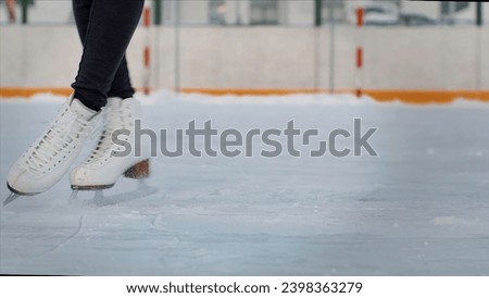 Professional female ice figure skater practicing spinning on outdoor skating rink. Video. Woman ice dancing surrounded by residential high rise houses.