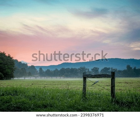 Sunset in Cades Cove Tennessee with fog layer over pasture  Royalty-Free Stock Photo #2398376971