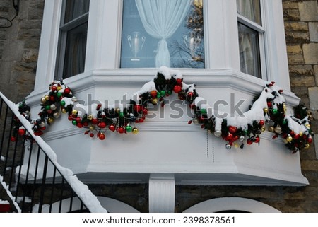 Front porch covered in Christmas holiday decorations and ornaments covered in snow in Montreal, Quebec, Canada