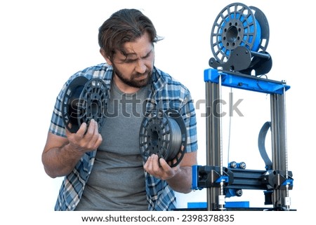 Man selecting filaments to make a 3D print. Royalty-Free Stock Photo #2398378835