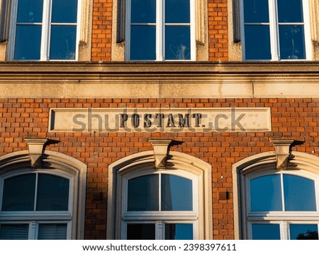 Postamt (post office) sign on an old building exterior. The letters are part of the facade design. Traditional architecture in a town with a postal service in Germany.