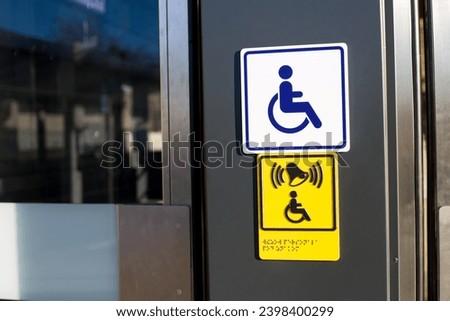 Sign with wheelchair and braille text for people with disabilities next to the entrance door