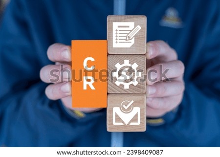 Man holding multi-colored blocks with icons sees on a orange block the abbreviation: CR. Change Request ( CR ) business concept.