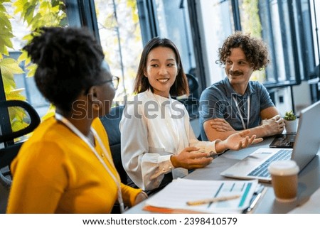 Multiethnic coworkers talking about serious topics in their office on the job Royalty-Free Stock Photo #2398410579