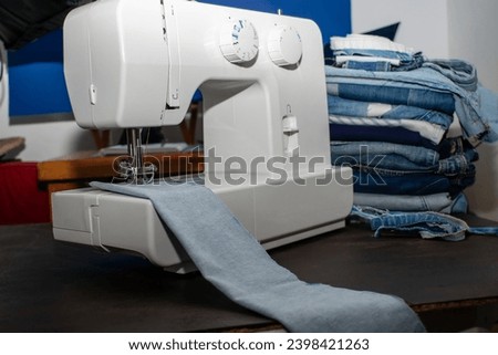 sewing machine with demim fabrics, the background out of focus with blue tones