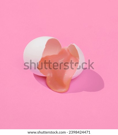 Creative layout with slime in broken chicken egg shell. Bright pink background with shadow. Visual trend. Easter, food conceppt. Minimalistic aesthetic still life. Fresh idea