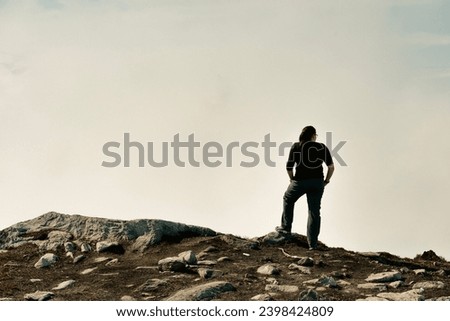 Woman looking out over the clouds from the top of a mountian