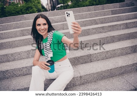 Photo of charming lovely woman dressed trendy clothes sitting on stairs recording video broadcasting streaming outside city street