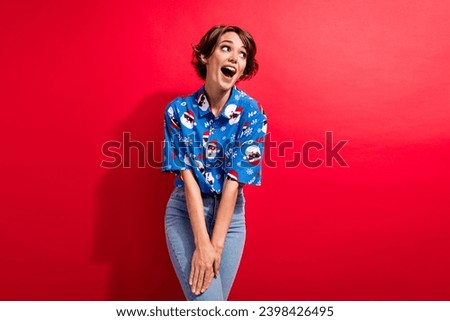 Portrait of looking empty space curious young girl celebrate happy new year laughing good proposition isolated on red color background