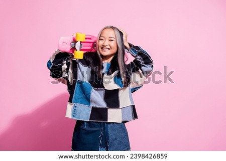 Photo of optimsitic gorgeous positive girl dressed jeans pullover holding skateboard hand on dyed hair isolated on pink color background Royalty-Free Stock Photo #2398426859
