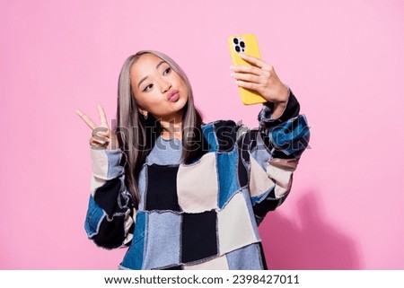Photo of charming girl with dyed hair dressed pullover make selfie on smartphone show v-sign pouted lips isolated on pink color background