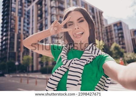 Selfie photo of young funky girlfriend showing v sign cover face tongue stick out enjoy spend weekend outdoors street residential complex
