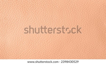 Peach fuzz color natural leather sample texture . Abstract leather background in trendy color 2024 year Peach Fuzz with copy space.