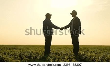 two businessmen farmers shake hands sunset. handshake sign agreement. Agriculture. making a deal field on a farm. handshake with business men. agro-industrial production. working people in the field.