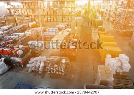 Overview of a large industrial modern warehouse storing products in cardboard boxes, bags and rolls.