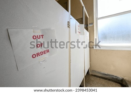 out of order sign on old bathroom stalls 