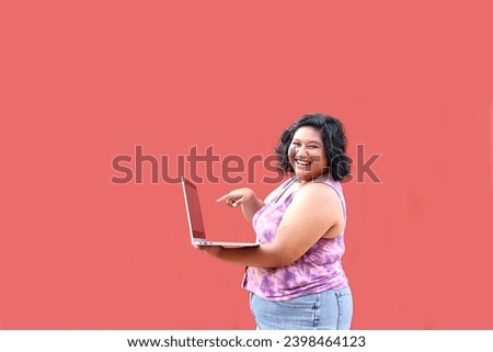 Young 20 year old overweight brunette Latina woman uses her laptop to study, do homework, date, shop online and chat with her friends