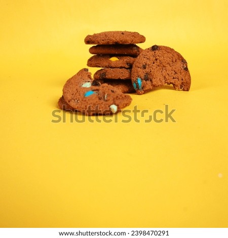 Close up shoot of chocolate cookies with colorful candies on yellow background