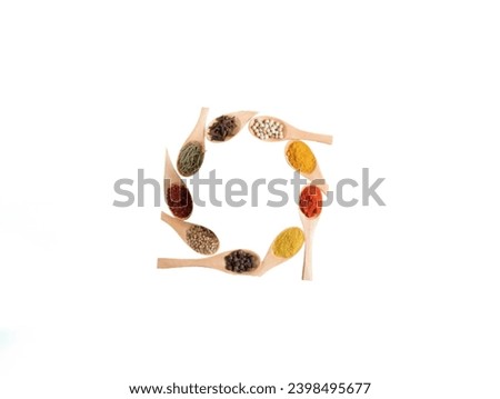 The white background in the picture is nine different kinds of multi-colored spices placed in wooden spoons arranged in circles.