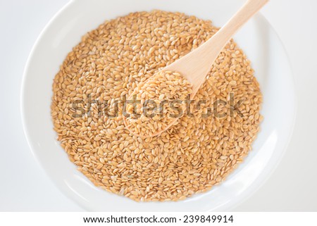 Gold flax seeds on a wooden spoon, stock photo