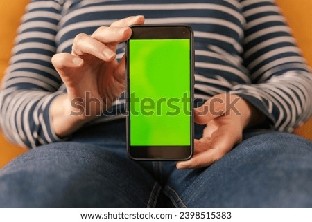 Close-up of female handsshowing black mobile phone with blank screen mockup