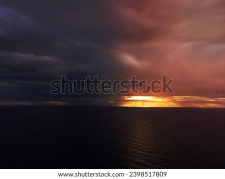 Aerial view from a flying drone of sunrise or sunset over ocean