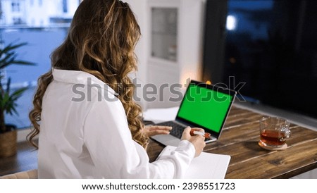 Young business women at her laptop green screen display - home shooting