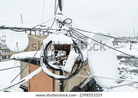 Telecommunications and satellite television. Communication problem due to bad weather. Satellite dishes covered with snow. Royalty-Free Stock Photo #2398553319