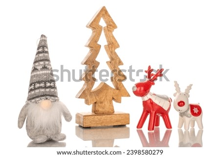 Two ceramic Christmas deer, wooden Christmas tree and gnome, macro, isolated on white background.