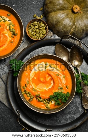 Pumpkin porridge with pumpkin seeds and cream. Autumn food concept. Top view. Royalty-Free Stock Photo #2398603383