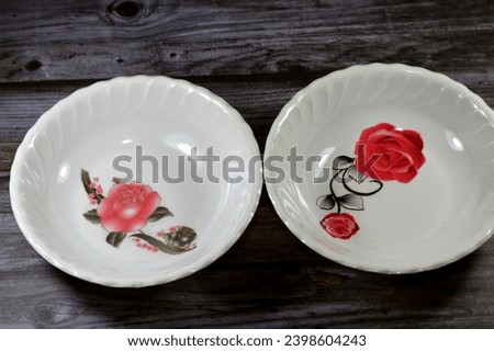 empty food plate used for serving food, with a picture of a red rose flower on the plate, utensils, kitchenware, and food concept, plastic deep plates, selective focus