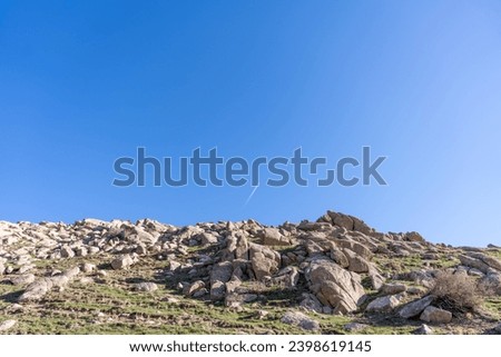 a beautiful mountain with a lot of rocks in the top of the mountain is small airplane going, Uzbekistan mountains, beautifully landscaped, high quality pictures.