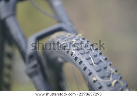 Tire and coat close up of a black electric bicycle bike with suspension fork in the background