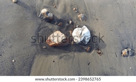 Stones in wet beach sand. Royalty-Free Stock Photo #2398652765