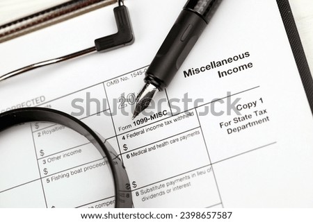 IRS Form 1099-misc Miscellaneous income blank on A4 tablet lies on office table with pen and magnifying glass close up Royalty-Free Stock Photo #2398657587