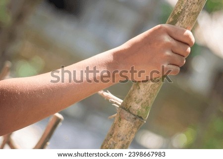 A man is holding dry bamboo by hand and blurred background