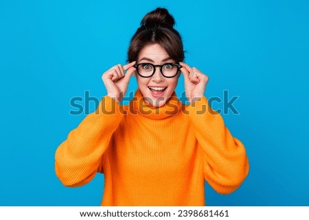 Photo of excited funky woman dressed orange sweater hands arms eyewear open mouth isolated blue color background