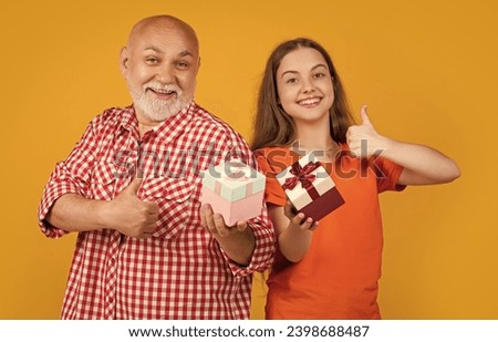 positive child and grandfather with present box for anniversary