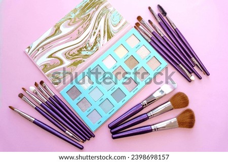 Close-up of professional makeup brushes and eye shadow on a pink background. Fashion and beauty concept. Macro, selective focus, horizontal photo, top view. Kyiv, Kiev, Ukraine, Europe.