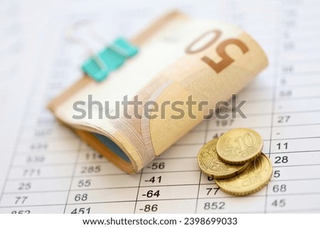 Heap of euro money bills in stationery clip on papers with calculations and receipts close up. Business and accounting concept