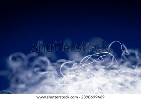 Extreme macro of polyester stable fiber on blue background. Selective focus, shallow depth of field. Abstract dreamy background Royalty-Free Stock Photo #2398699469