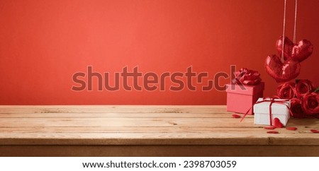 Valentine's day background with empty wooden table, gift box and heart shapes. Holiday mock up for design and product display