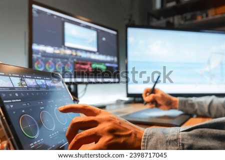 Asian male creator, film editor works with footage or video on his personal computer, in his creative office studio.