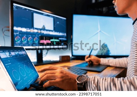 Asian male creator, film editor works with footage or video on his personal computer, in his creative office studio. tell to environmental story