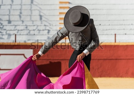 Hispanic matador dancing on sandy arena Royalty-Free Stock Photo #2398717769